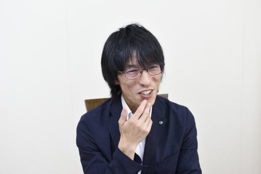インタビュー画像:白い壁の部屋で椅子に座り、これから介護者を目指す方へコメントされている藤上さんの様子