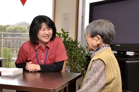 画像:利用者の方の自宅にて、女性の利用者の方と会話している原さんの様子。